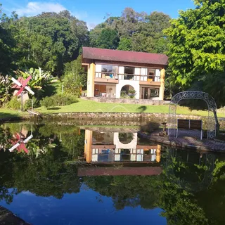 Foto da fachada de uma casa em Lajeado, Brasil, com paisagem de água e vegetação exuberante.
