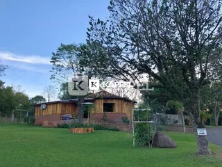 Foto da área externa com gramado e uma estrutura de madeira em um terreno.