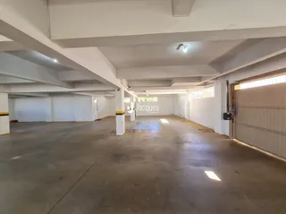 Espaço interno com piso de concreto e teto branco.