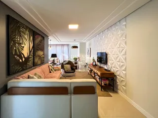Sala de estar com sofá e decoração de parede em um imóvel no Brasil.