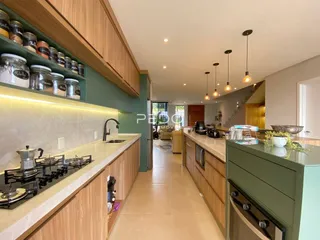 Vista da cozinha moderna com armários de madeira e bancadas claras.