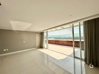Vista de uma sala ampla com portas de vidro que se abrem para uma área externa.