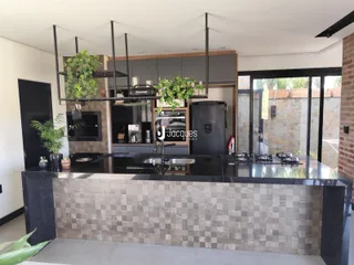 Vista da cozinha moderna com ilha e armários escuros.