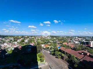 Vista aérea de uma área residencial em Lajeado, Brasil, mostrando casas e vegetação.