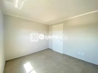 Ambiente interno com paredes brancas e piso de cerâmica.