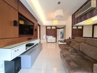 Sala de estar com sofá e painel de TV em um imóvel no Brasil.