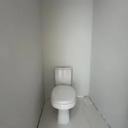 Foto de um banheiro com um vaso sanitário branco.