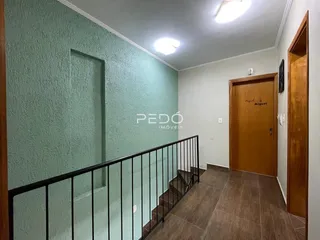 Hall de entrada com escadaria e corrimão em um imóvel no Brasil.
