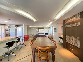 Uma sala de jantar com mesa de madeira e ambiente claro.