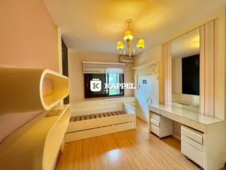 Quarto com cama e piso de madeira clara em um ambiente bem iluminado.