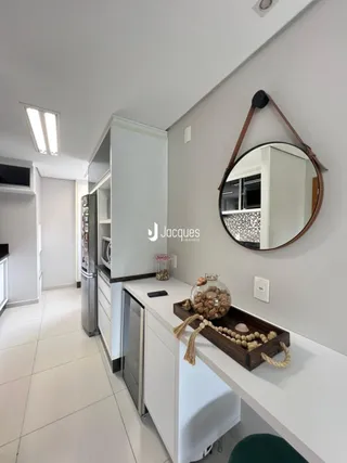 Vista de um corredor interno com armários e espelho em uma residência.