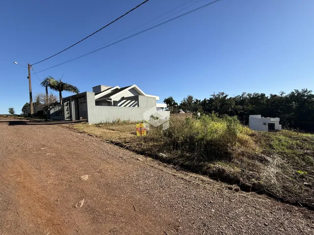 Vista da fachada de uma casa em uma área rural com estrada de terra.