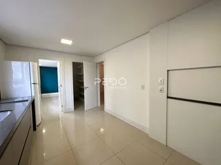 Corredor com piso de cerâmica claro e paredes brancas.