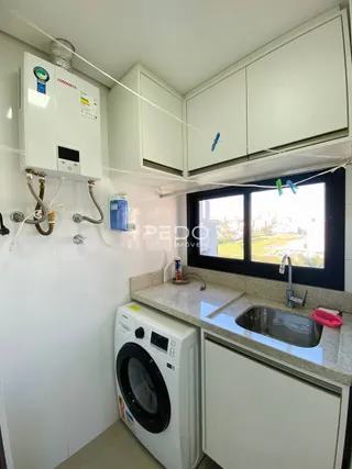 Interior de uma cozinha com armários brancos e máquina de lavar roupa.