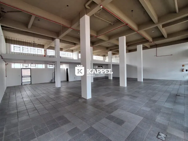 Vista interna de um grande hall com colunas e piso de cerâmica.