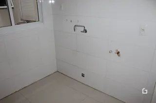 Parede interna branca com piso claro em uma residência.