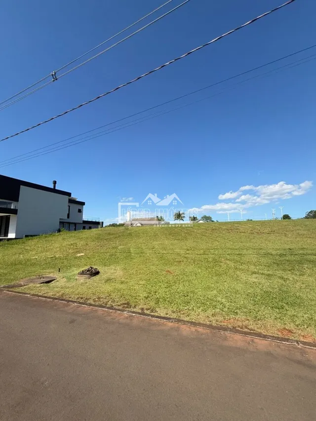 Vista externa de uma propriedade com gramado e estrada.