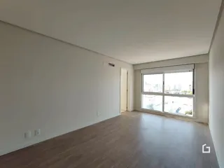 Foto de um cômodo interno com piso de madeira e paredes brancas.
