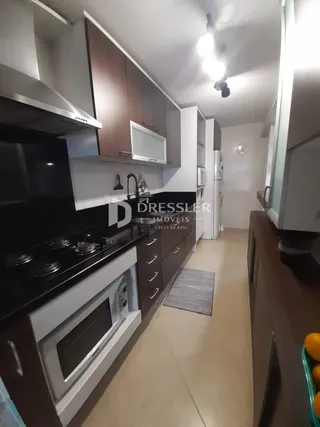 Foto de uma cozinha com armários escuros e bancada preta.