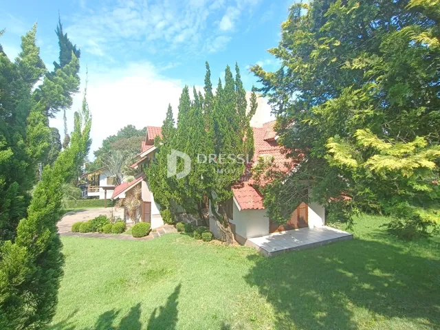 Fachada de uma casa em Lajeado, Brasil, cercada por árvores e gramado.
