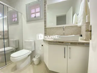 Foto de um banheiro com dois vasos sanitários e bancada de mármore.