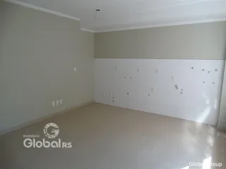 Foto de uma sala ampla com paredes claras e piso de cor neutra.
