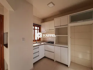Foto de uma cozinha com armários brancos e bancada.