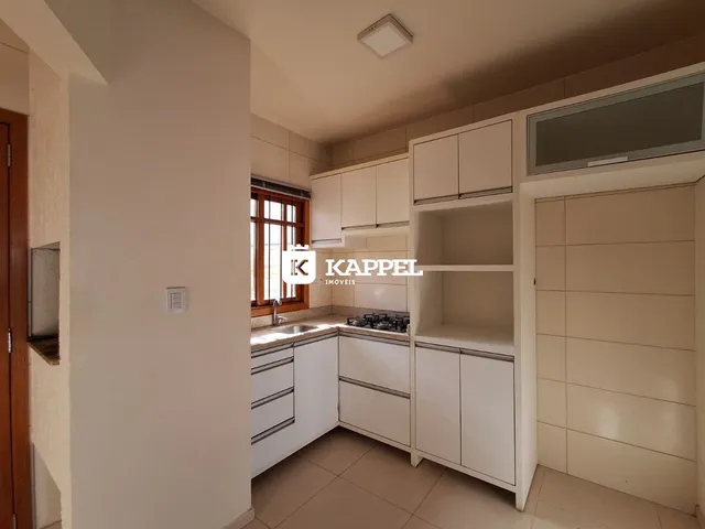 Foto de uma cozinha com armários brancos e bancada.