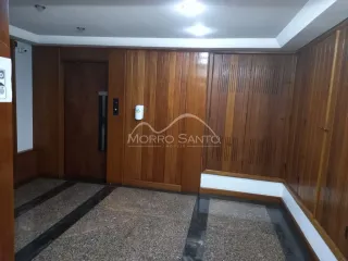 Interior com painéis de madeira e piso de carpete em um ambiente residencial.