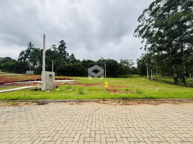 A foto mostra uma área gramada com uma estrutura de concreto ao lado de uma estrada pavimentada.