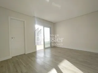 Interior de uma sala com paredes brancas e porta branca.