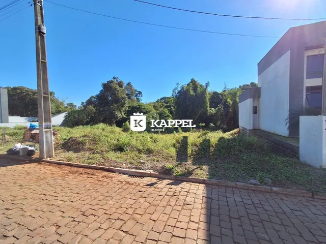 Fachada de uma residência em Lajeado, Brasil, com área externa gramada e pavimento de tijolos.
