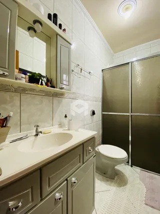 Foto de um banheiro com bancada e vaso sanitário.