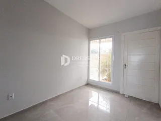 Interior de uma sala com paredes brancas e piso de cerâmica clara.