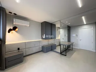 Interior moderno de uma sala de estar com paredes cinzas e móveis em tons de cinza.