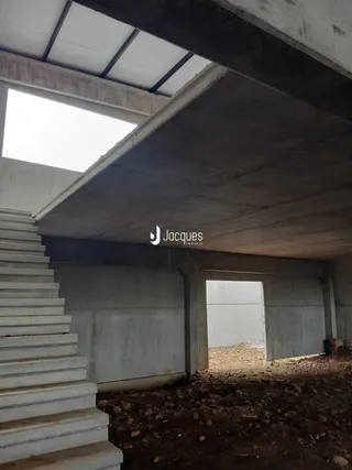 Foto de uma área interna em construção com escadas de concreto.