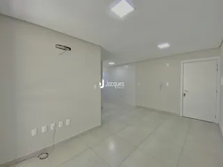 Corredor interno de uma residência com paredes brancas e piso claro.