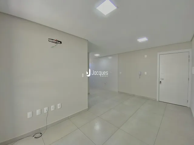 Corredor interno de uma residência com paredes brancas e piso claro.