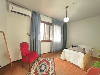 Quarto com janela e cortinas em uma residência.