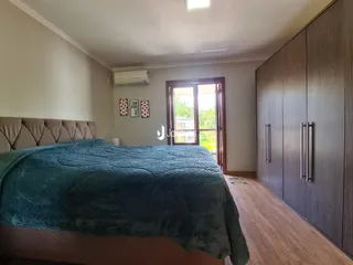 Quarto com cama e armário de madeira em um imóvel no Brasil.