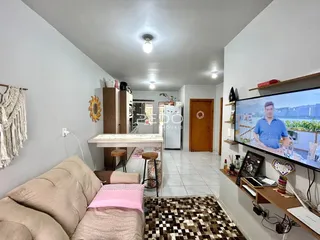 Sala de estar com sofá e área de jantar em um imóvel no Brasil.