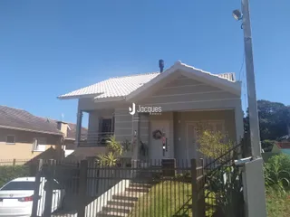 Fachada de uma casa em Lajeado com cerca e jardim.