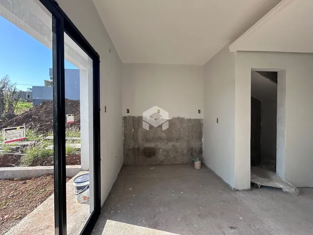 Interior de um espaço com paredes brancas e piso de concreto aparente.