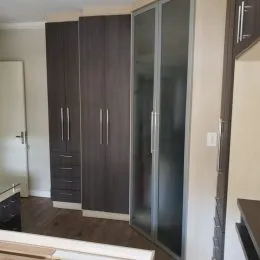 Armários altos de madeira escura em um ambiente interno.