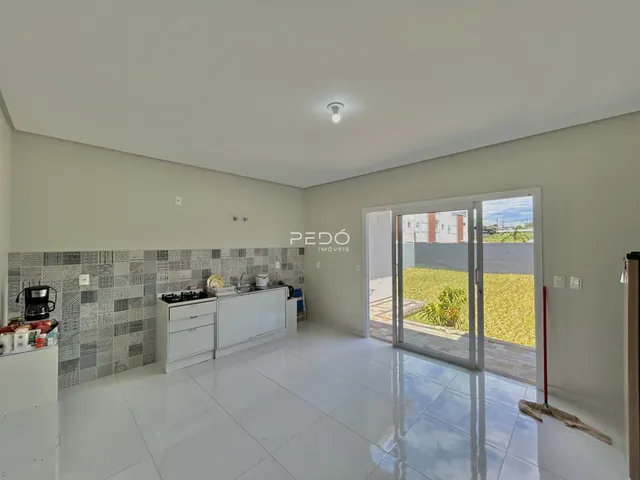 Vista da cozinha de uma propriedade em Lajeado, Brasil, com piso de cerâmica branco e portas de vidro.