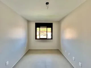 Vista interna de um cômodo com paredes brancas e piso claro.