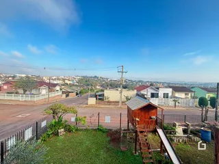 Vista da propriedade com um quintal e cerca em frente a uma rua.