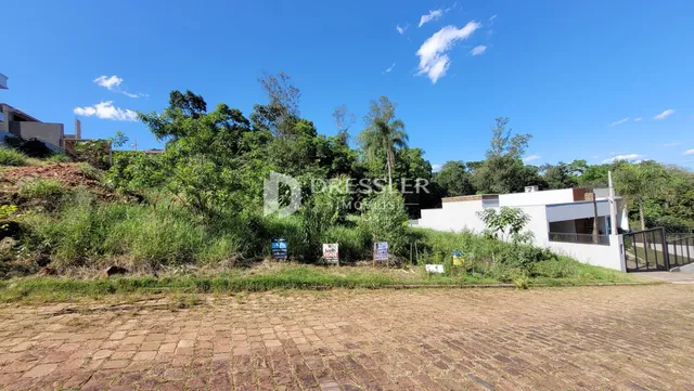 Vista externa de uma propriedade com vegetação densa ao fundo.