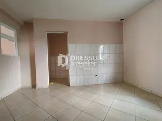 Interior de um ambiente com piso de cerâmica e paredes claras.