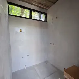 Foto interna de um corredor com paredes brancas.